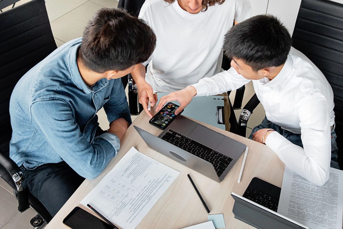 A team gathered around a laptop, working through an integration issue together